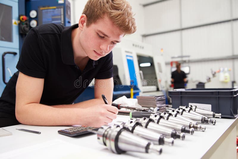 Engineer Planning Project with CNC Machinery in Background Stock Image