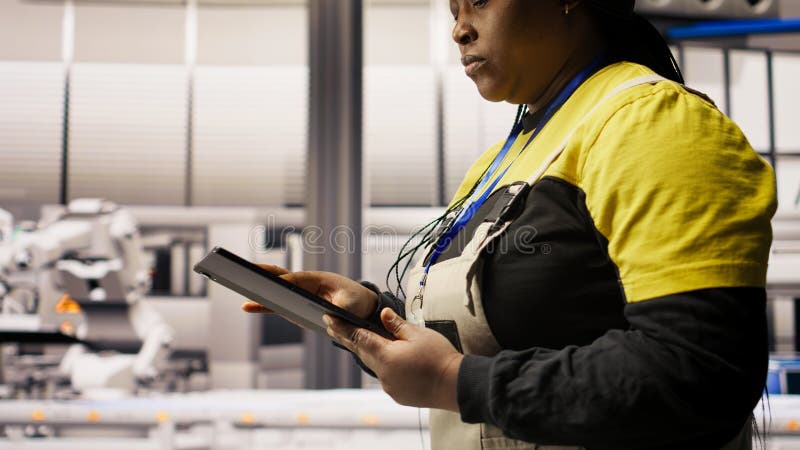 Engineer in smart solar manufacturing facility calibrating high tech machinery royalty free stock photography