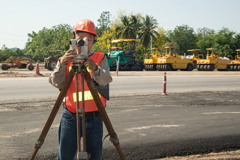 Engineer or Surveyor Working with Theodolite Equipment at Road