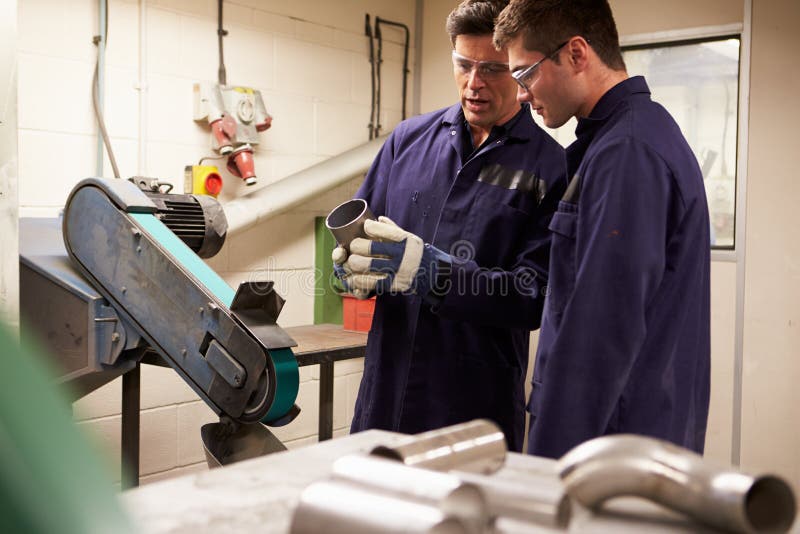 Engineer Teaching Apprentice To Use Grinding Machi stock images