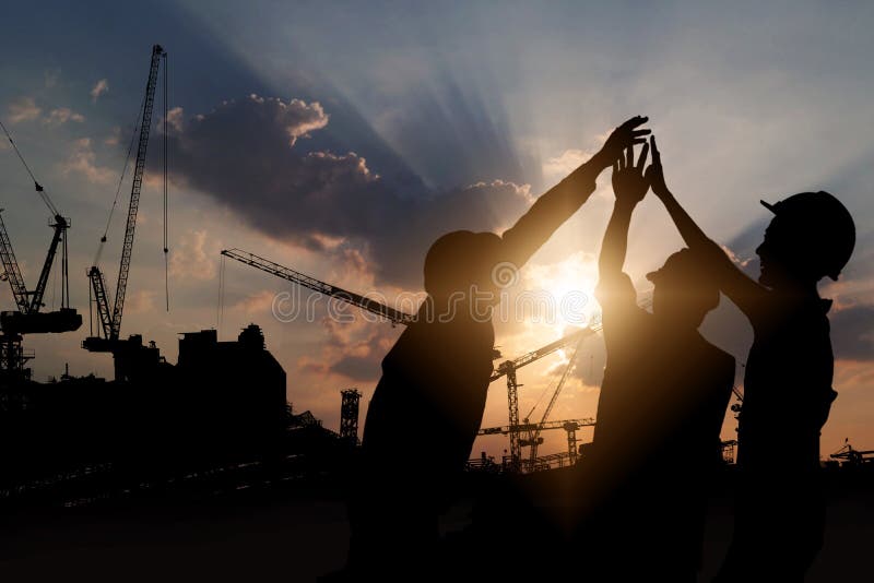 Engineer teamwork, silhouette of construction worker team touching hand together for power at working site