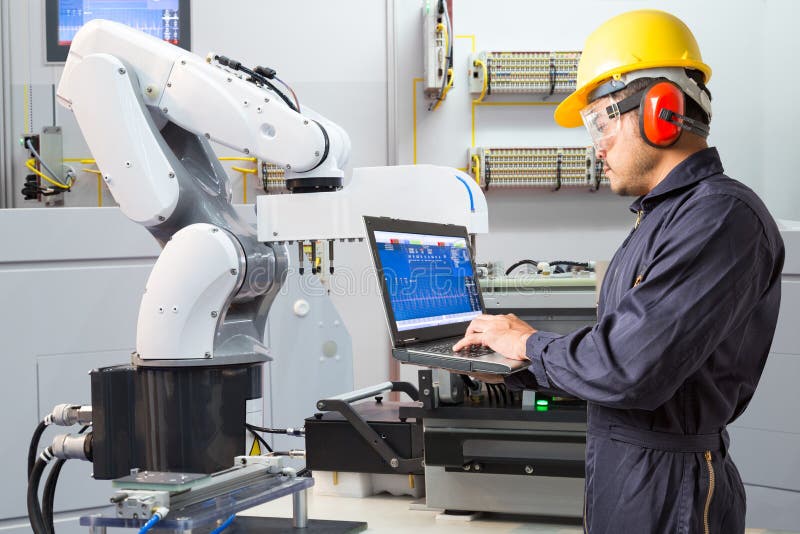Engineer using computer for maintenance automatic robotic industry stock photo Engineer using computer for maintenance automatic robotic industry stock photo