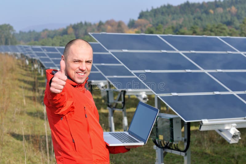 Engineer using laptop at solar panels plant field stock photography Engineer using laptop at solar panels plant field stock photography