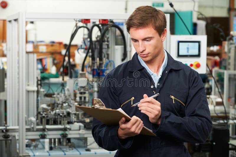 Engineer Writing On Clipboard In Factory.