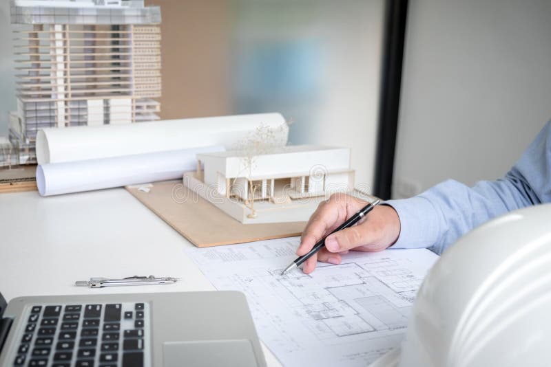 Engineering or Creative architect in construction project, Engineers hands working on construction blueprint and building model stock photo Engineering or Creative architect in construction project, Engineers hands working on construction blueprint and building model stock photo