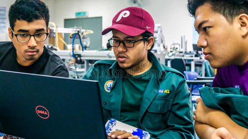 Engineering students discussing and solving the task given on the automation machine system in the laboratory royalty free stock photos