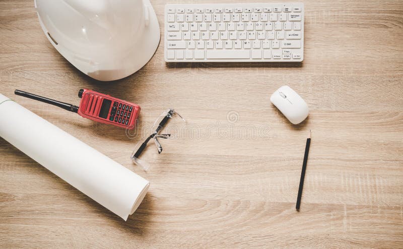 Engineering tools on work table for construction project.With a white helmet, radio and blueprints. Safety control.