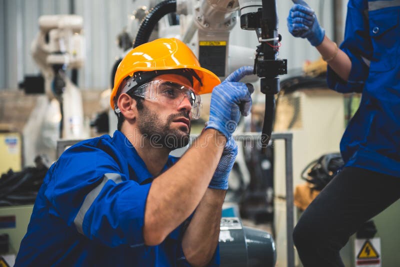 Engineers mechanic using computer controller Robotic arm for welding steel in steel factory workshop. Industry robot programming royalty free stock photo