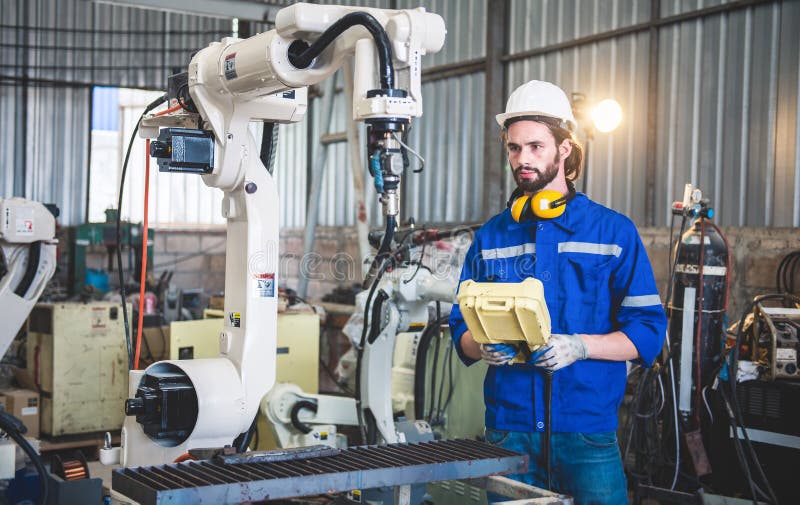 Engineers mechanic using computer controller Robotic arm for welding steel in steel factory workshop. Industry robot programming stock photography