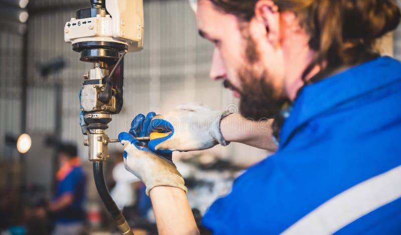 Engineers mechanic using computer controller Robotic arm for welding steel in steel factory workshop. Industry robot programming software for automated manufacturing technology.