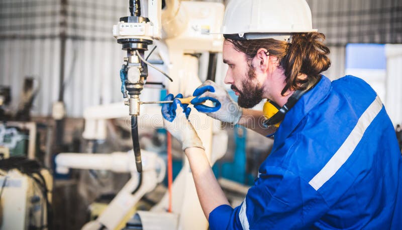 Engineers mechanic using computer controller Robotic arm for welding steel in steel factory workshop. Industry robot programming stock photo