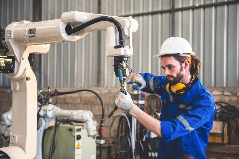 Engineers mechanic using computer controller Robotic arm for welding steel in steel factory workshop. Industry robot programming stock images