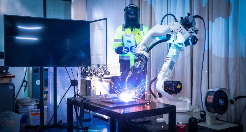 Engineers mechanic using computer controller Robotic arm for welding steel in steel factory workshop. Industry robot programming royalty free stock image
