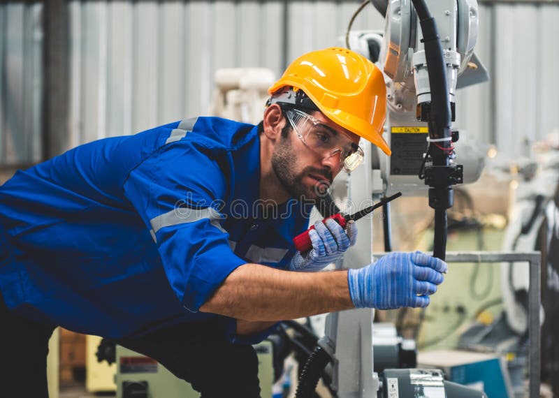 Engineers mechanic using computer controller Robotic arm for welding steel in steel factory workshop. Industry robot programming stock photo