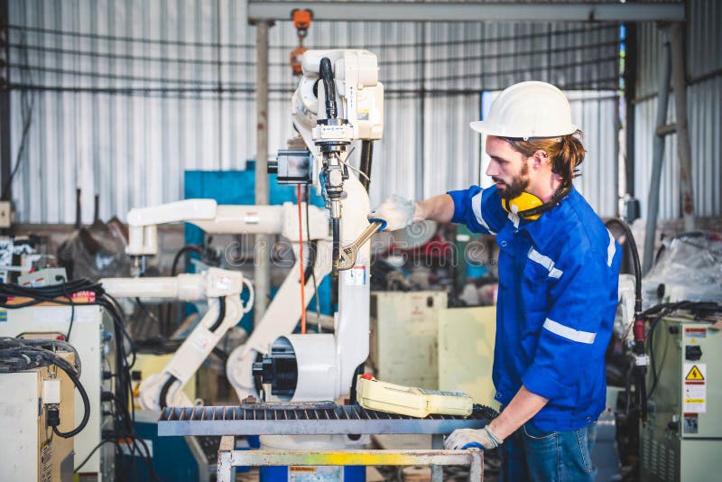 Engineers mechanic using computer controller Robotic arm for welding steel in steel factory workshop. Industry robot programming royalty free stock photos