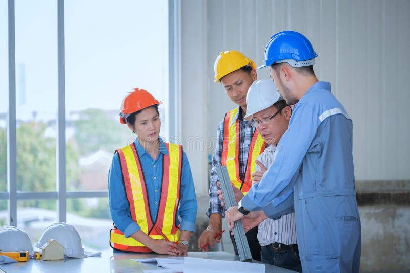 Engineers are meeting, working and looking at Home blueprint in stock image Engineers are meeting, working and looking at Home blueprint in stock image