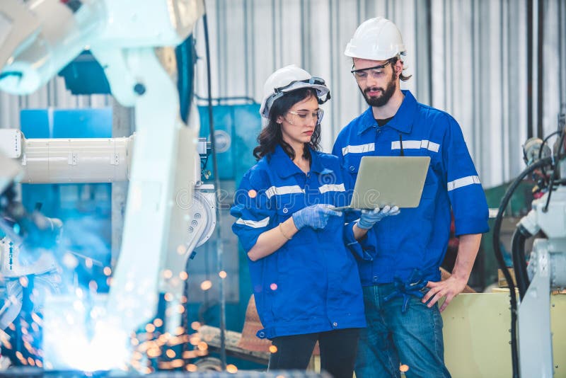 Engineers team mechanic using computer controller Robotic arm for welding steel in steel factory workshop. Industry robot stock photos