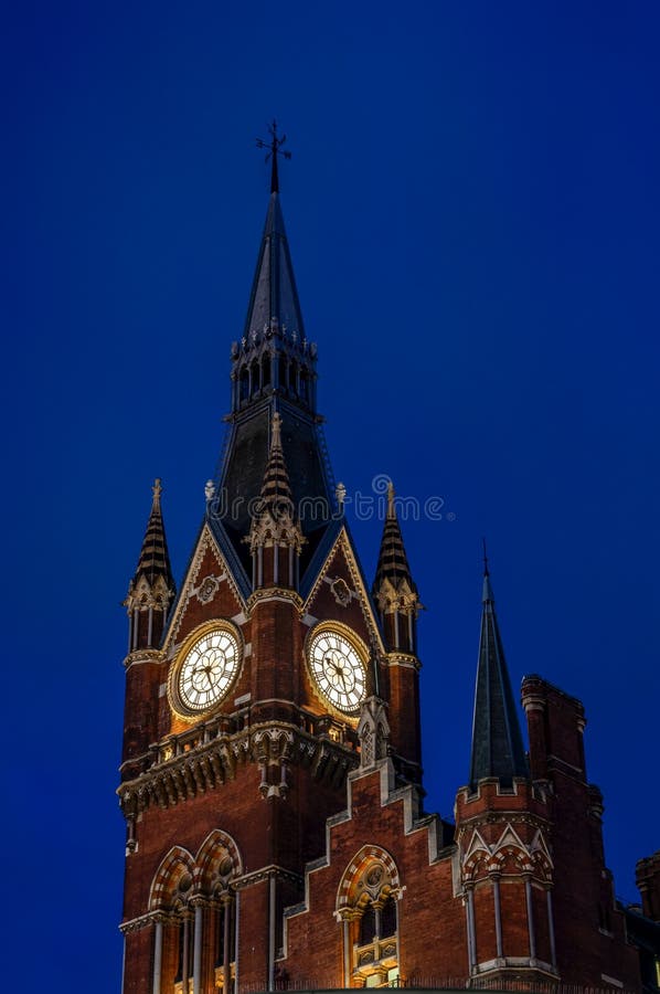 English landmarks and railroad stations concept with the clock tower at St Pancras international train station in London,UK at. Night against the dark blue sky stock photo English landmarks and railroad stations concept with the clock tower at St Pancras international train station in London,UK at. Night against the dark blue sky stock photo