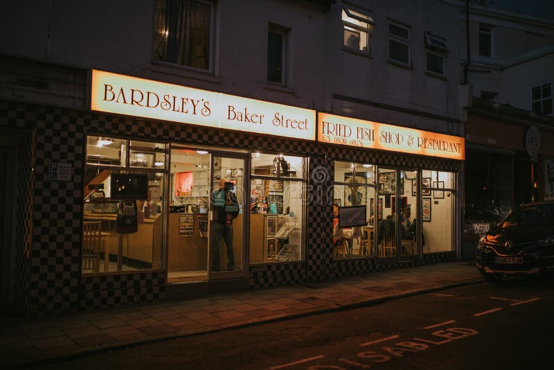 English restaurant shopfront at night.