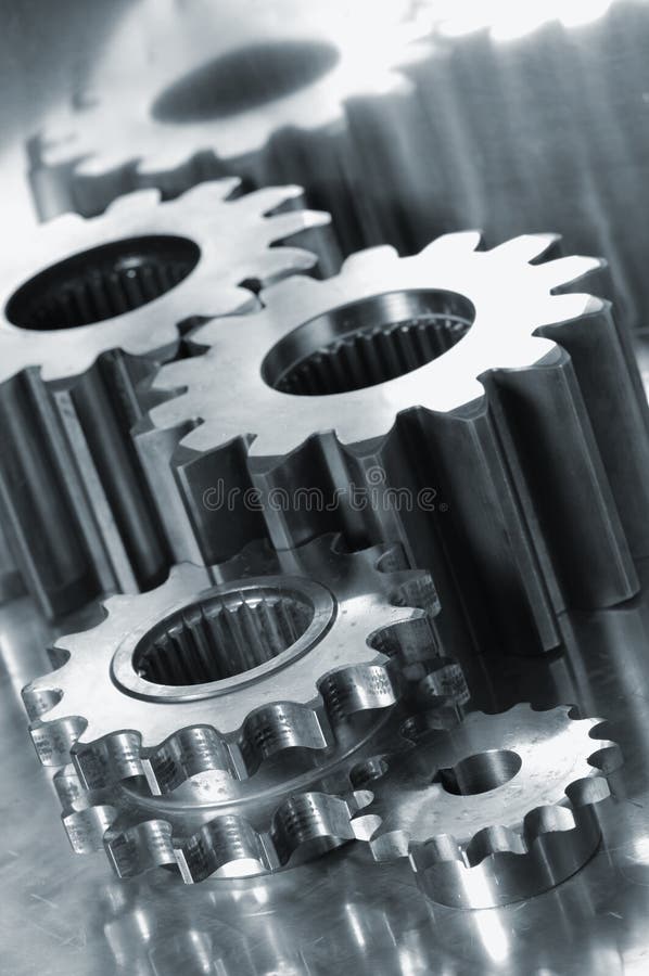 Gears and pinions close-up connection in a metallic cast, titanium background. Gears and pinions close-up connection in a metallic cast, titanium background