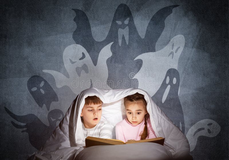 Engrossed little kids reading book in bed royalty free stock image Engrossed little kids reading book in bed royalty free stock image
