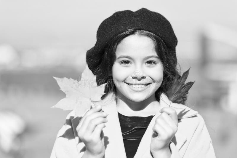 Enjoy season. Little girl adore autumn season. Kid cute face hold maple leaves. Small girl wear fall outfit outdoors