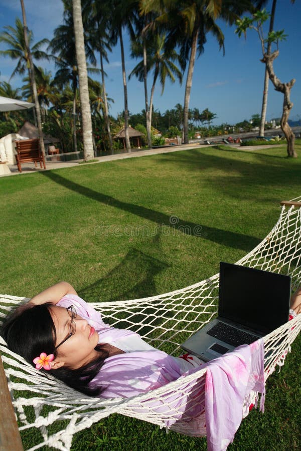 Asian businesswoman working on her vacation at the beach. Asian businesswoman working on her vacation at the beach