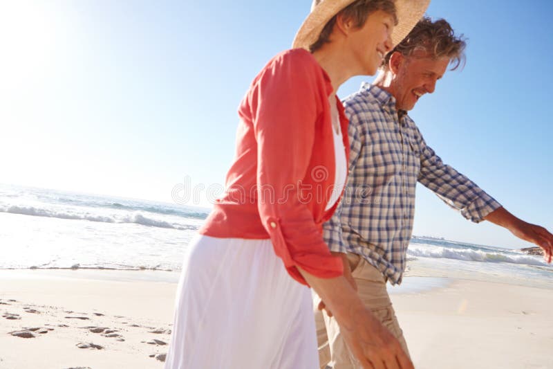 Enjoying A Perfect Day Of A Perfect Vacation A Mature Couple Enjoying A Late Afternoon Walk On