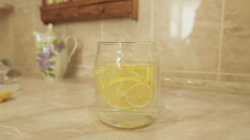 Enjoying Refreshing Lemon Water Served in a Beautiful Glass Jar Perfect for Summer Days stock images