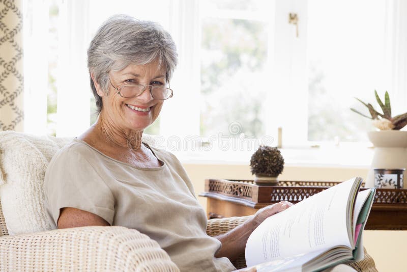 Una donna che mostra che si gode la pensione entro il relax e la lettura di un libro.