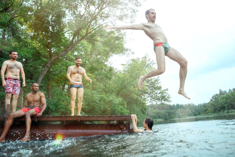 Enjoying river party with friends. Group of beautiful happy young people at the river together stock photo Enjoying river party with friends. Group of beautiful happy young people at the river together stock photo