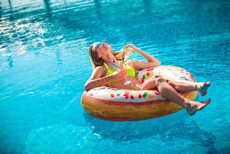 Enjoying suntan Woman in bikini on the inflatable mattress in the swimming pool royalty free stock photos Enjoying suntan Woman in bikini on the inflatable mattress in the swimming pool royalty free stock photos