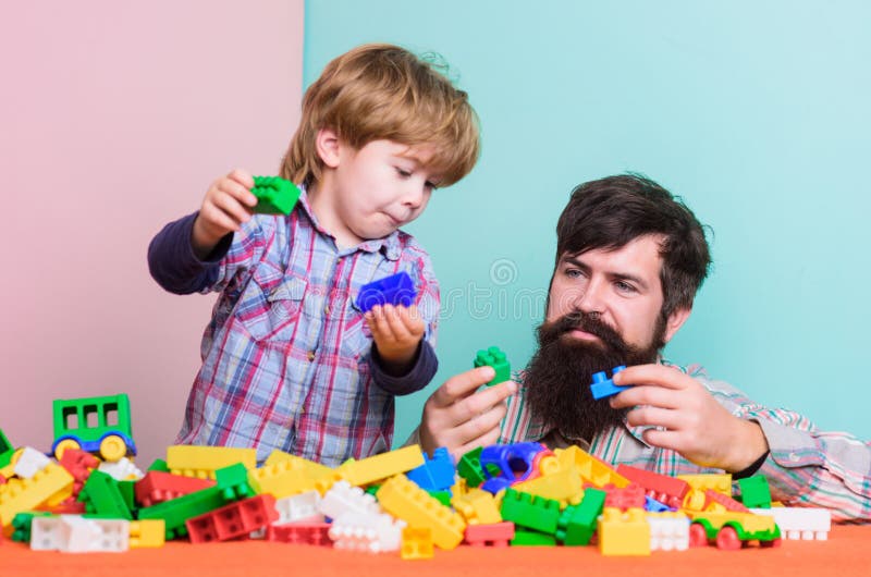 Enjoying time in play club. love. child development. father and son play game. happy family leisure. small boy with dad stock photo Enjoying time in play club. love. child development. father and son play game. happy family leisure. small boy with dad stock photo