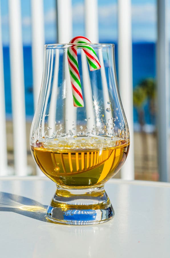 Enkelt exponeringsglas för maltwhisky med godisrottingen, symbolet av Christm royaltyfri foto Enkelt exponeringsglas för maltwhisky med godisrottingen, symbolet av Christm royaltyfri foto