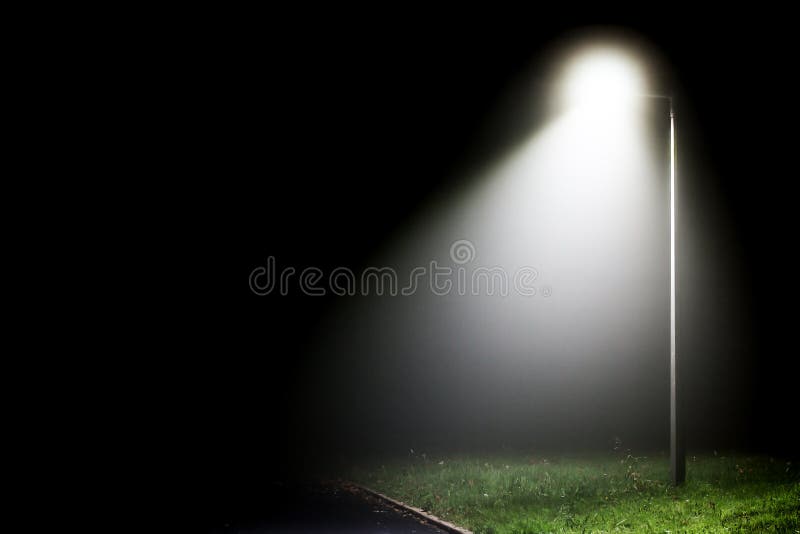 Single street light illuminating the darkness on a rural road side. Single street light illuminating the darkness on a rural road side