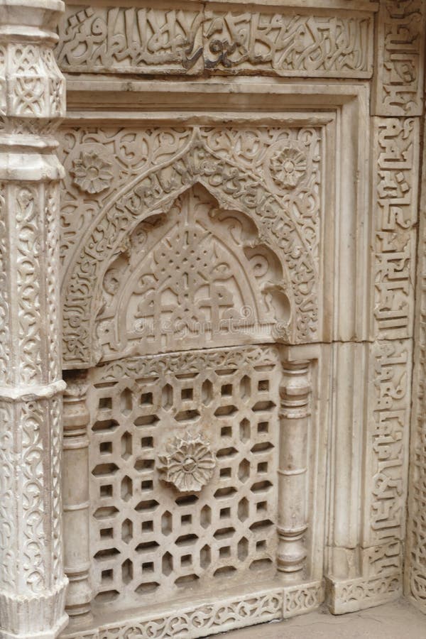 Intricate carvings on the mihrab of the Tomb of slave dynasty sultan Iltutmish from 13th century, Qutb Minar complex, Delhi, India. Intricate carvings on the mihrab of the Tomb of slave dynasty sultan Iltutmish from 13th century, Qutb Minar complex, Delhi, India