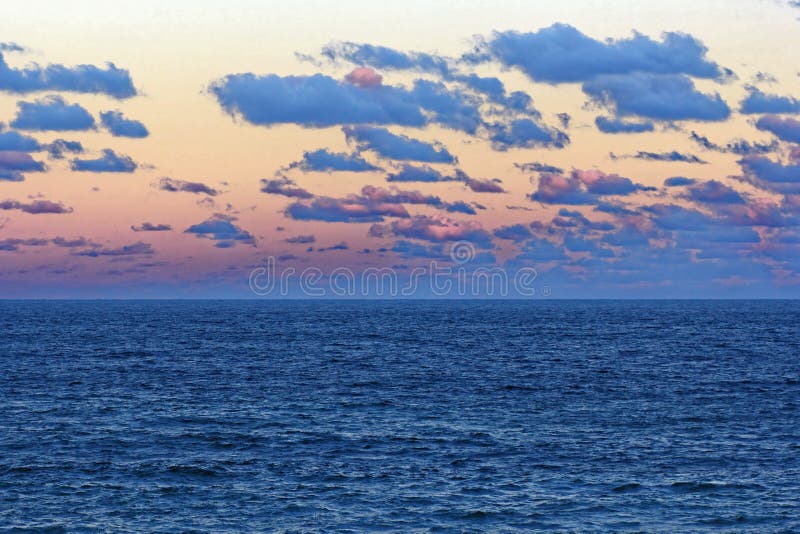 Enorm oceaanlandschap door bewolkte hemel bij zonsondergang stock foto Enorm oceaanlandschap door bewolkte hemel bij zonsondergang stock foto