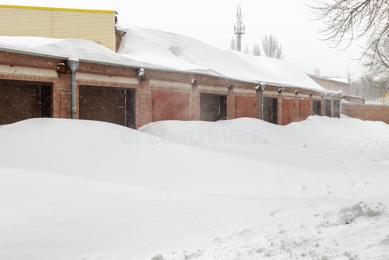 Enorm snö packar ihop nära garagedörrar i vinter under häftig snöstorm arkivbild Enorm snö packar ihop nära garagedörrar i vinter under häftig snöstorm arkivbild