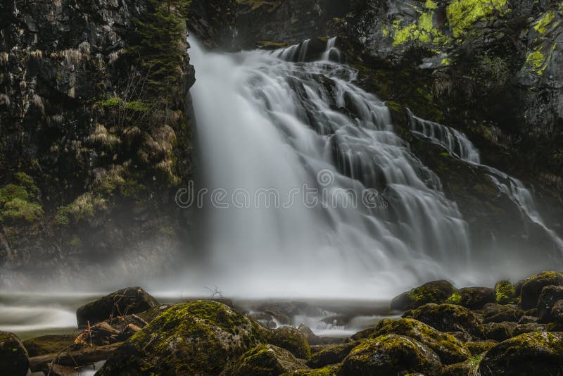Enormer Wasserfall mit Felsen in der Front stockbilder