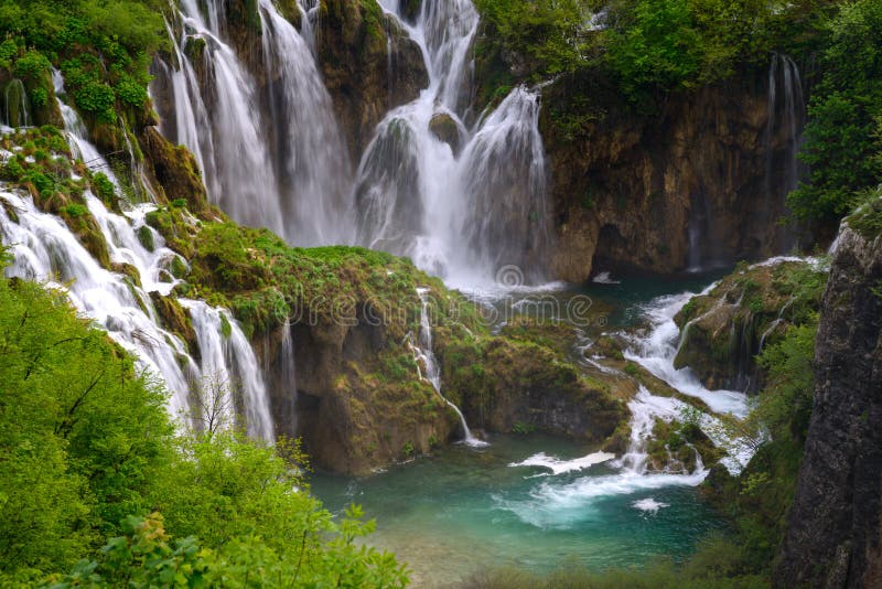 Enormer Wasserfall unter üppigem Laub lizenzfreie stockbilder