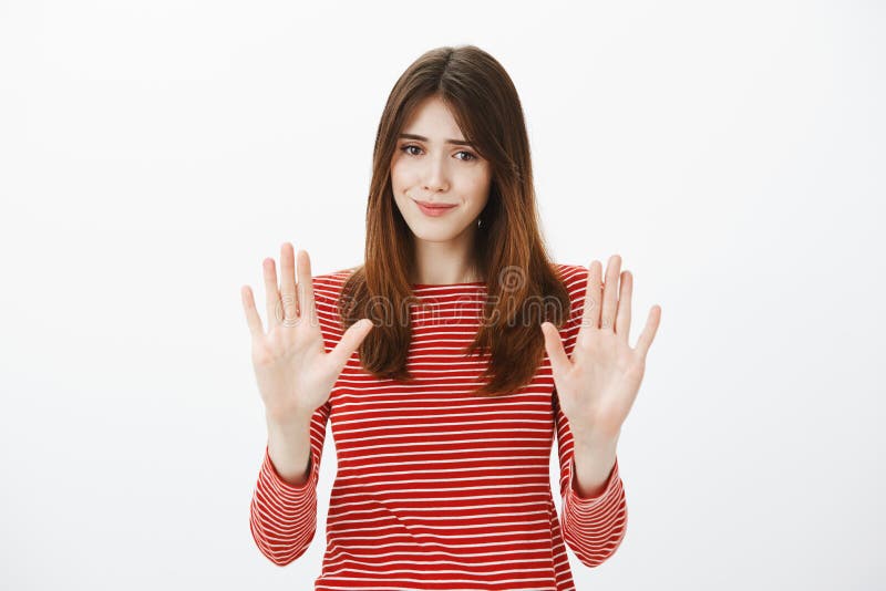 That is enough, thanks. Portrait of uncomfortable pretty brunette, raising palms in no or stop gesture, smiling awkwardly, wanting to decline offer politely, feeling insecure and nervous. Copy space