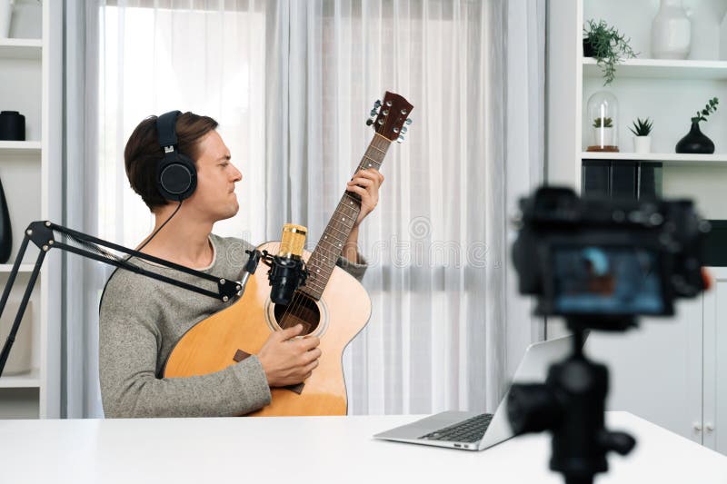 Enregistrement de chanteuse intelligente par caméra jouant de la guitare en chantant. pécuniaire. photographie stock
