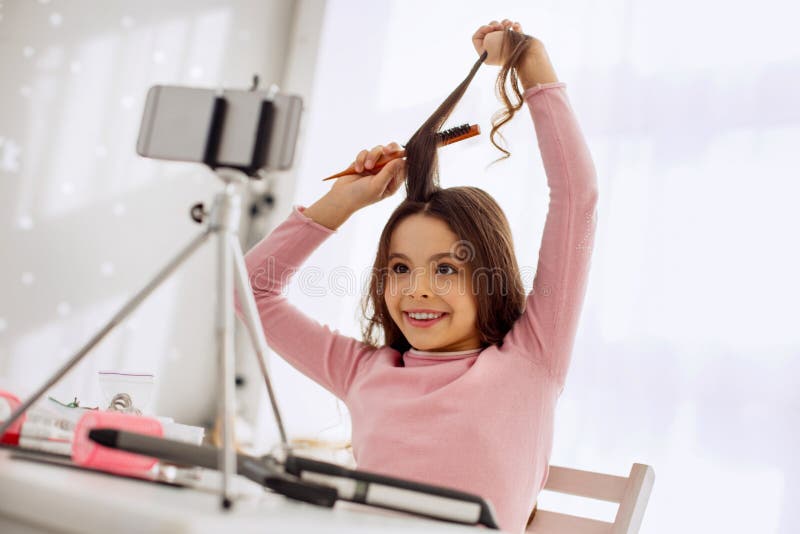 Enregistrement heureux de fille elle-même tout en balayant des cheveux photo libre de droits Enregistrement heureux de fille elle-même tout en balayant des cheveux photo libre de droits