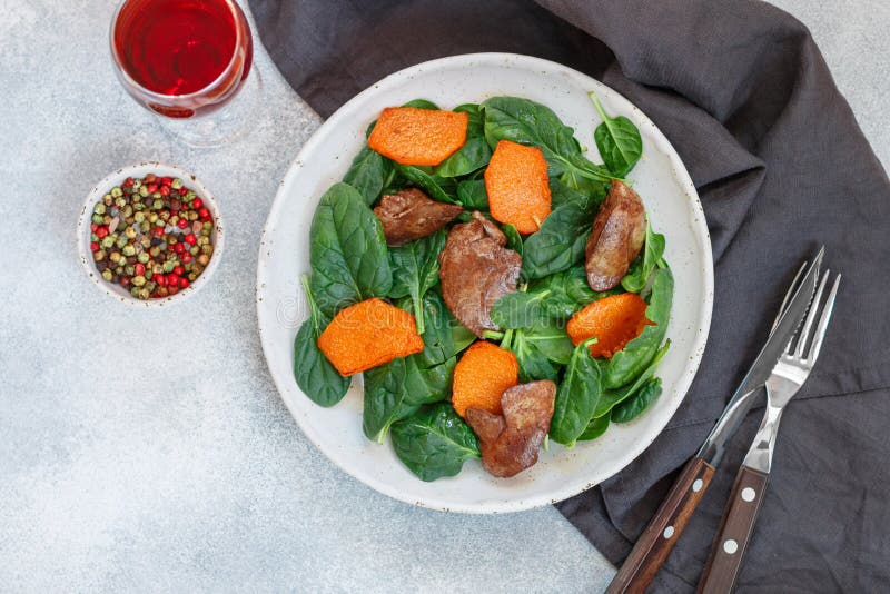 Ensalada caliente de la espinaca con el hígado de pollo y la calabaza cocida fotos de archivo libres de regalías Ensalada caliente de la espinaca con el hígado de pollo y la calabaza cocida fotos de archivo libres de regalías