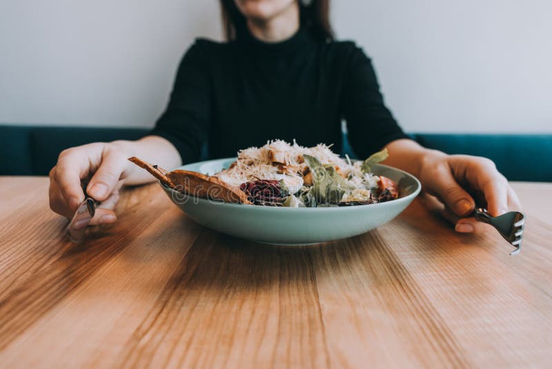 Ensalada de Flatlay con las manos, el cuchillo y la bifurcación de la muchacha imágenes de archivo libres de regalías
