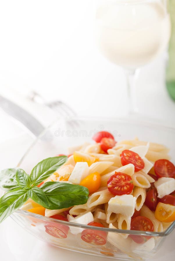 Ensalada de pasta deliciosa con los tomates frescos del mozarella y de cereza, albahaca foto de archivo libre de regalías Ensalada de pasta deliciosa con los tomates frescos del mozarella y de cereza, albahaca foto de archivo libre de regalías