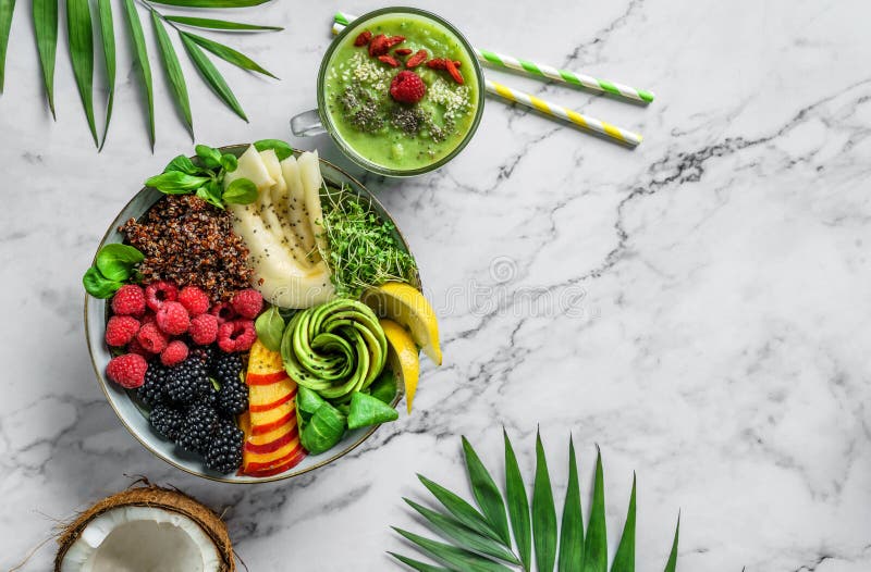 Fresh summer salad with quinoa, peach, micro greens, avocado, berries, coconut, melon on light marble background with tropical leaves. Healthy food, clean eating, Buddha bowl salad, detox, top view. Fresh summer salad with quinoa, peach, micro greens, avocado, berries, coconut, melon on light marble background with tropical leaves. Healthy food, clean eating, Buddha bowl salad, detox, top view