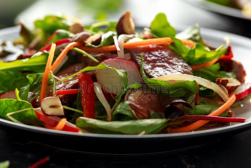 Ensalada picante de la carne de vaca con las zanahorias, el rábano, los brotes de haba, los chiles, las nueces y la mezcla verde imagen de archivo libre de regalías Ensalada picante de la carne de vaca con las zanahorias, el rábano, los brotes de haba, los chiles, las nueces y la mezcla verde imagen de archivo libre de regalías