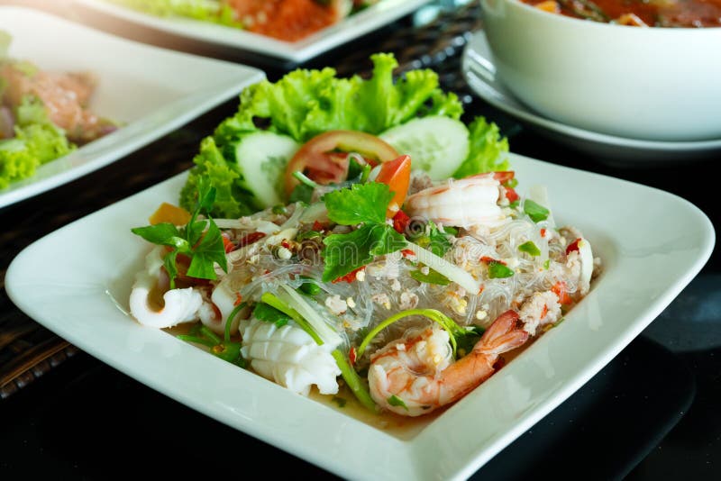 Ensalada picante de los tallarines, ensalada picante de los fideos con el camarón fresco y calamar, estilo tailandés de la comida foto de archivo Ensalada picante de los tallarines, ensalada picante de los fideos con el camarón fresco y calamar, estilo tailandés de la comida foto de archivo