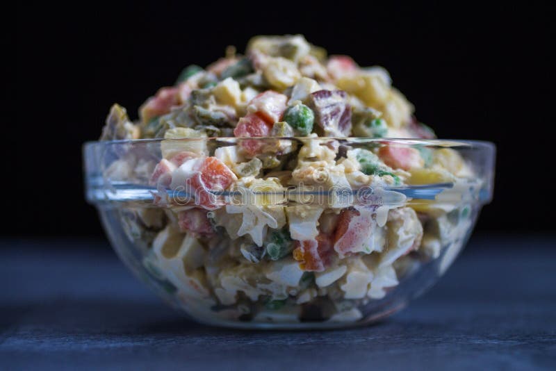 Ensalada russa ou salada Olivier no fundo escuro da bacia de vidro fotos de stock Ensalada russa ou salada Olivier no fundo escuro da bacia de vidro fotos de stock
